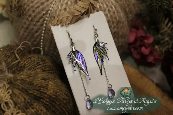 Boucles d'oreilles longues depareillees violettes et vertes, sur carte