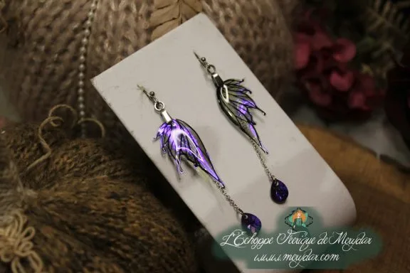 Boucles d'oreilles longues depareillees violettes et noires avec perle violette, sur carte
