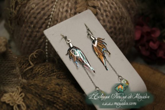Boucles d'oreilles longues depareillees blanches et orange avec perle, sur carte