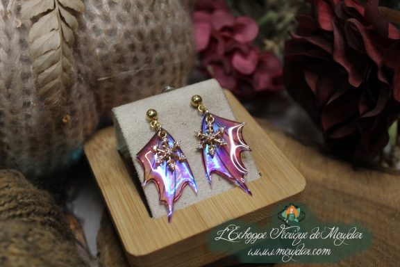 Boucles d'oreilles ailes de fee roses, presentees sur socle en bois