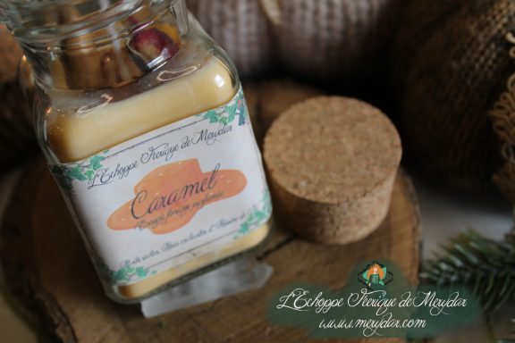 Bougie en pot cire beige avec etiquette Caramel, presentee sur bois avec bouchon liege