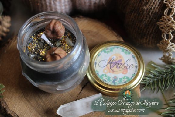 Bougie en pot cire foncee pailletee doree avec gland, etiquette Ambre