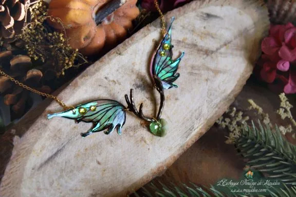 Collier pendentif bois de cerf avec deux ailes turquoise vertes et perle verte, presente sur bois
