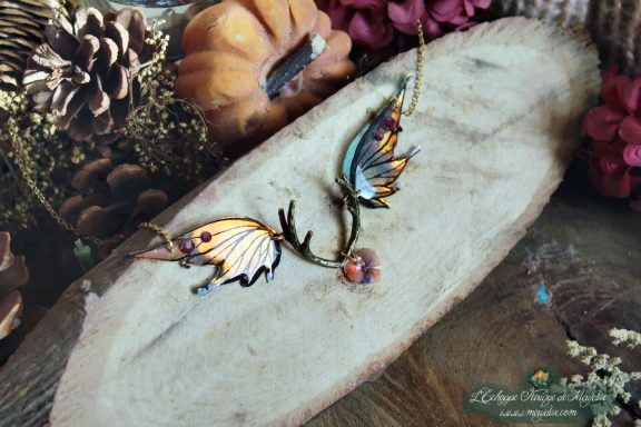Collier pendentif bois de cerf avec deux ailes jaunes orange et perle violette, gros plan