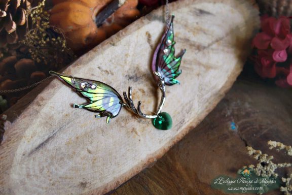 Collier pendentif bois de cerf avec deux ailes turquoise bleues et perle verte, gros plan