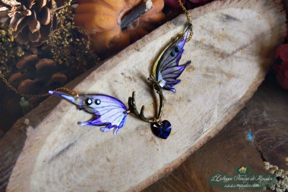 Collier pendentif bois de cerf avec aile bleue violette et perle coeur bleue, gros plan