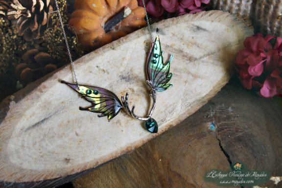 Collier pendentif bois de cerf avec aile verte violette et perle sombre, gros plan