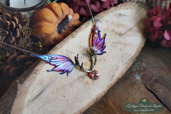 Collier pendentif bois de cerf avec aile violette et perle ambree, gros plan