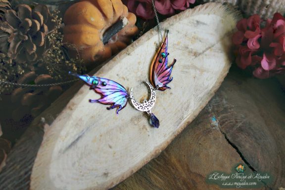 Collier pendentif bois de cerf avec aile bleue et breloque lune, perle violette, gros plan