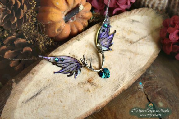 Collier pendentif bois de cerf avec aile violette verte et perle turquoise, gros plan