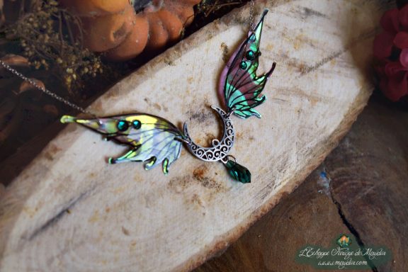 Collier pendentif bois de cerf avec aile verte jaune et perle sombre, presente sur bois