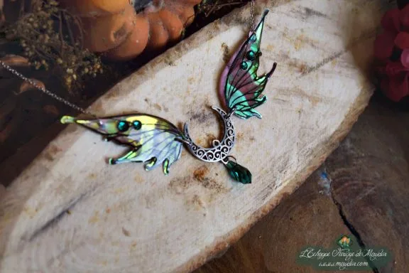 Collier pendentif bois de cerf avec aile verte jaune et perle sombre, presente sur bois