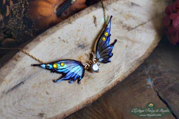 Collier pendentif aile bleue violette avec breloque lune, gros plan sur bois