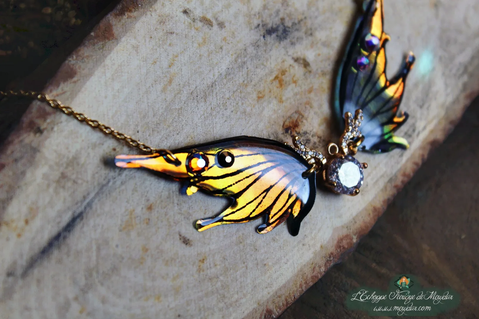 Collier pendentif papillon orange et bleu entier avec pierre transparente, presente sur buste