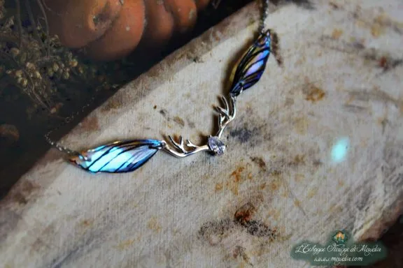 Pendentif fine aile bleue avec breloque bois de cerf, gros plan sur bois