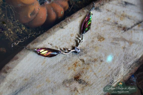 Pendentif fine aile rouge violette avec breloque bois de cerf, gros plan sur bois