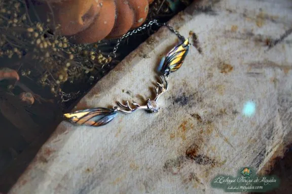 Pendentif fine aile orange avec breloque bois de cerf, gros plan sur bois