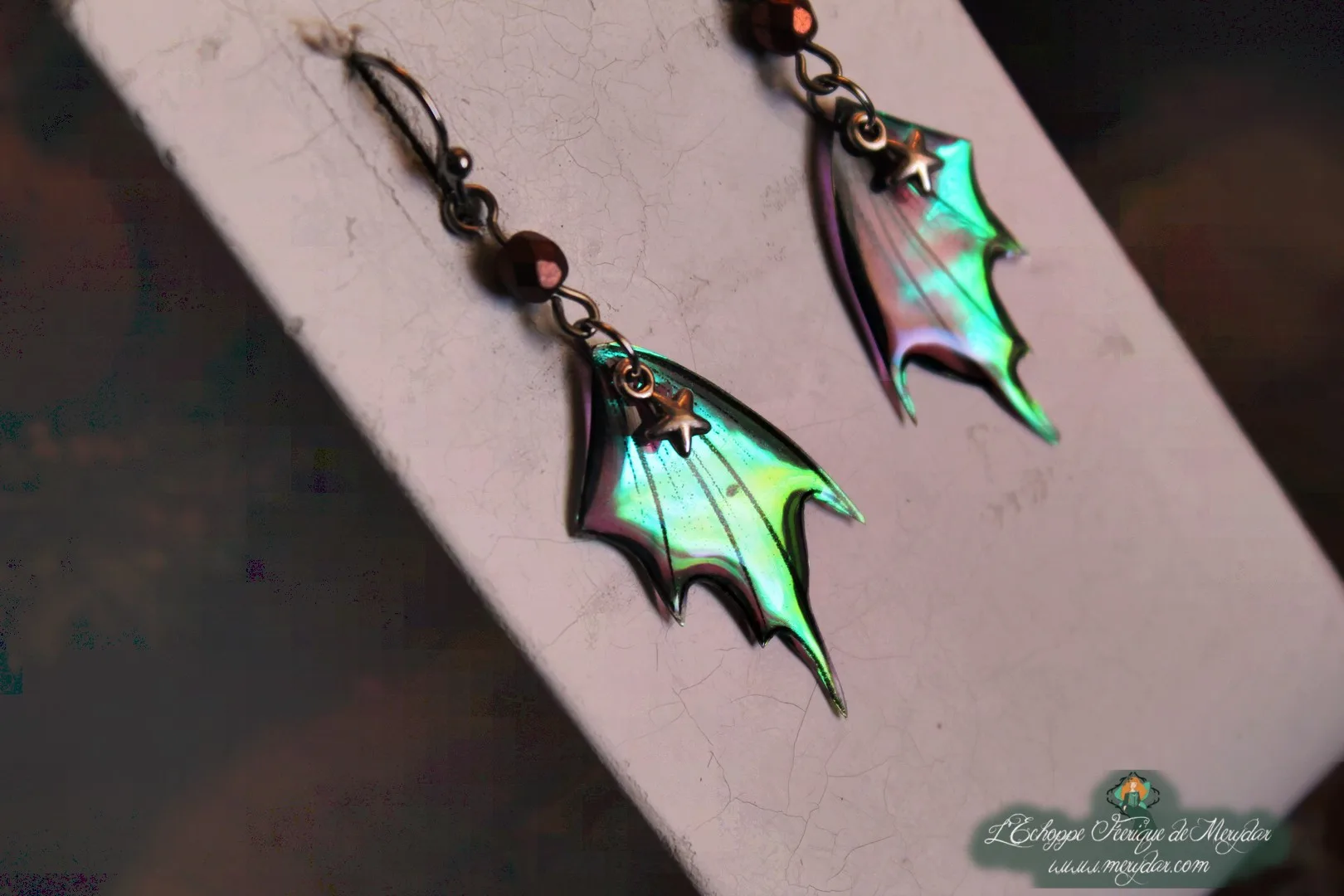 Boucles d'oreilles ailes de chauve-souris turquoise avec breloque etoile, sur socle
