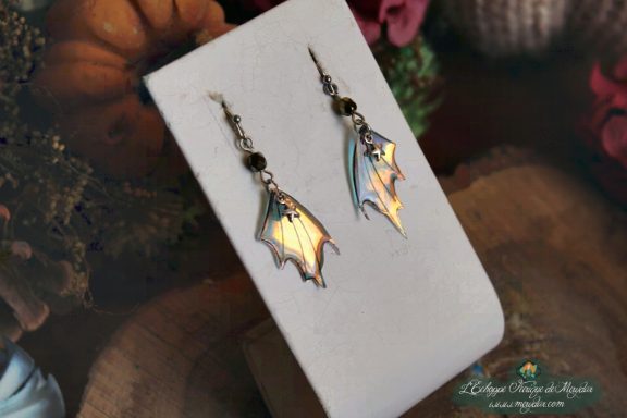 Boucles d'oreilles ailes de chauve-souris blanches dorees, sur socle