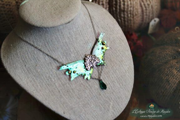 Collier pendentif renard aile turquoise verte avec perle verte, presente sur buste porte-bijoux