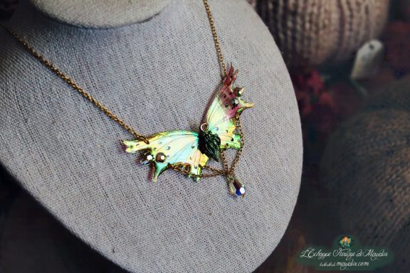 Collier pendentif renard aile turquoise avec breloque et perle rouge, presente sur buste
