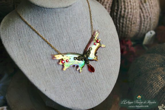 Collier pendentif renard petite aile jaune avec breloque et perle rouge, presente sur buste