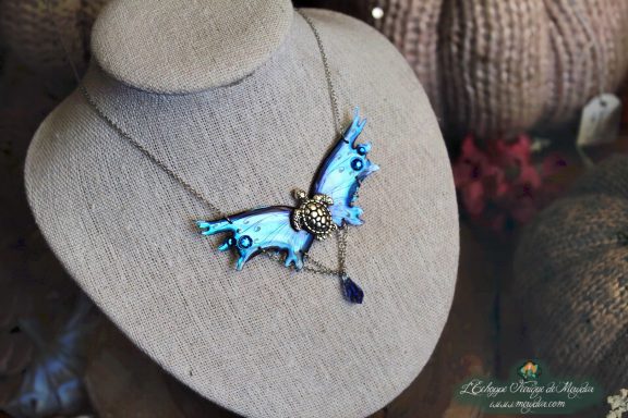 Collier pendentif renard petite aile bleue avec breloque et perle bleue, presente sur buste