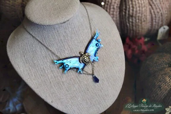 Collier pendentif renard petite aile bleue avec breloque et perle bleue, presente sur buste