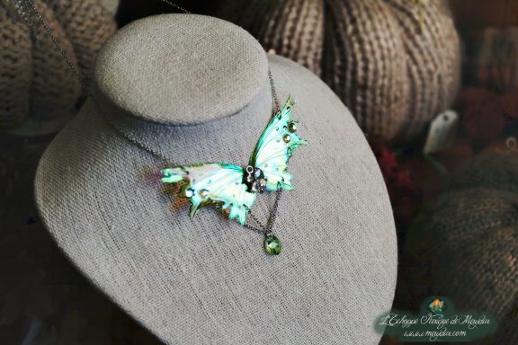 Collier pendentif renard aile turquoise avec perles, presente sur buste porte-bijoux