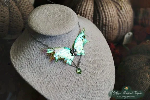 Collier pendentif renard aile turquoise avec perles, presente sur buste porte-bijoux