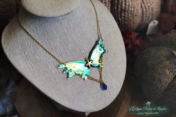 Collier pendentif renard aile turquoise avec breloque etoile et perle bleue, presente sur buste