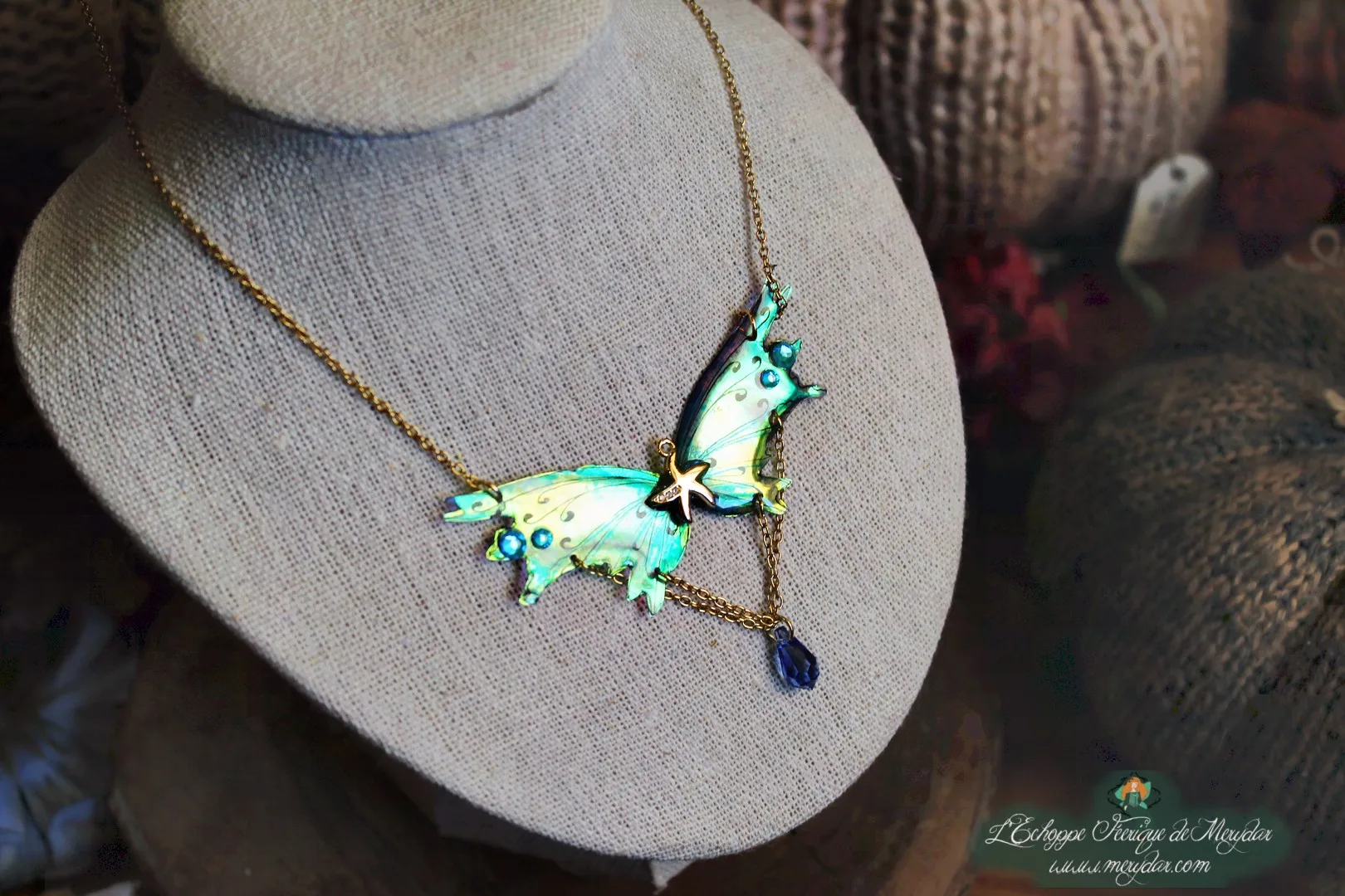 Collier pendentif renard aile turquoise avec breloque etoile et perle bleue, presente sur buste