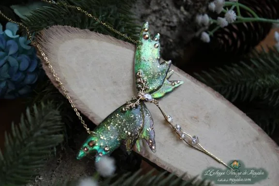 Collier pendentif aile de mite cosmique verte entiere avec epingle pendante, sur bois