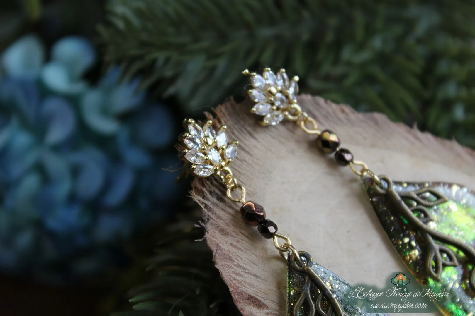Boucles d'oreilles longues feuille verte jaune avec motif vigne, vue rapprochee sur bois