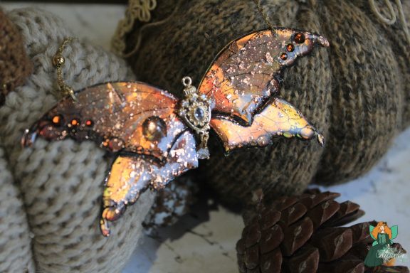 Pendentif aile de chauve-souris orange doree pailetee avec gemmes