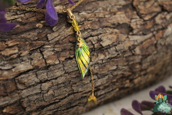 Pendentif aile plume jaune avec perle ambre pendante, gros plan