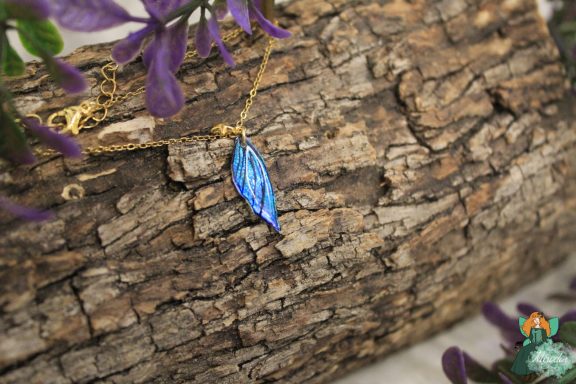 Petit pendentif aile plume bleue sur chaine doree