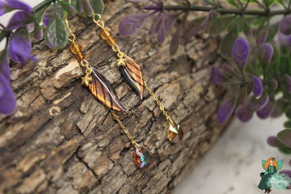 Boucles d'oreilles aile plume orange avec breloques etoile et gemme bleue