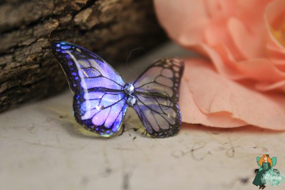 Broche papillon violet avec gemme centrale