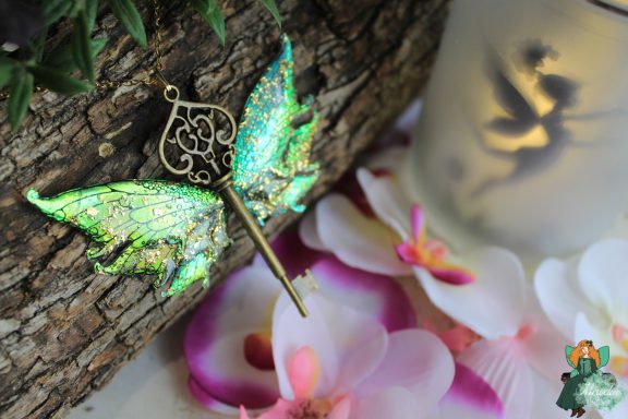 Pendentif cle ailee verte avec bordure bronze ornee
