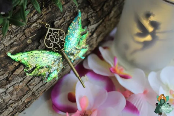 Pendentif cle ailee verte avec bordure bronze ornee