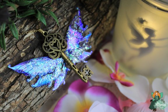 Pendentif cle ailee bleue violette avec bordure bronze ornee