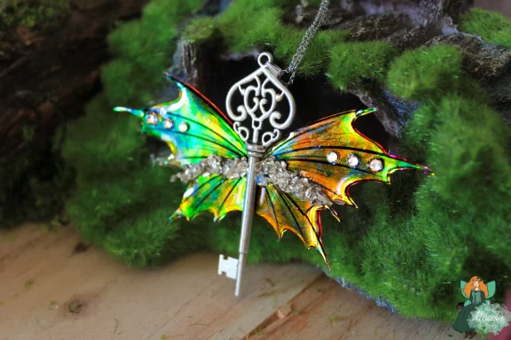 Pendentif cle ailee orange jaune pailetee, argentee
