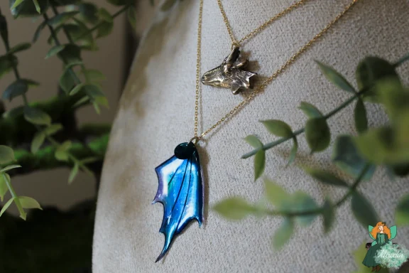 Collier double chaine avec breloque tete de loup et pendentif aile de dragon bleue
