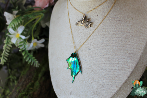 Collier avec breloque tete de loup et pendentif aile de dragon verte, sur buste
