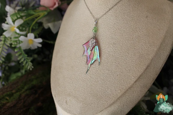 Petit pendentif aile de dragon verte, chaine doree sur buste