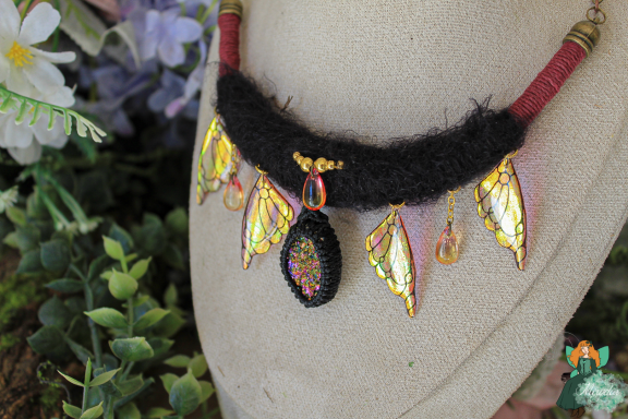 Collier ras-de-cou noir avec ailes ambre pendantes et perle pailetee