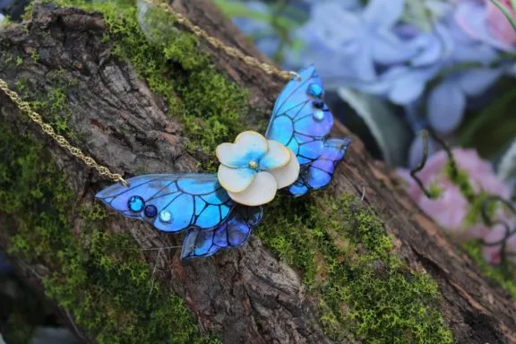 Pendentif aile de fee bleue avec fleur, chaine sur mousse
