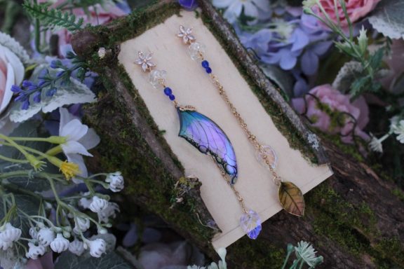 Boucles d'oreilles aile violette avec perles bleues, sur carte