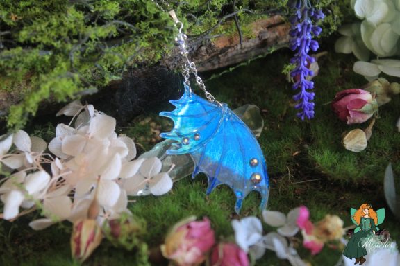 Pendentif aile de dragon bleue, chaine sur mousse